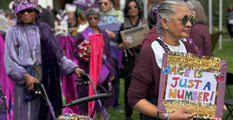 Participants at the Age Well Festival holding a sign that reads, Age Is Just A Number