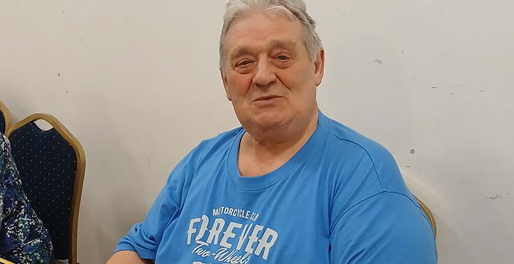 Bob Brown sitting down, working as a Hub Host at bingo