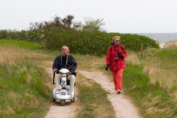 Couple experiencing accessible holiday using mobility scooter