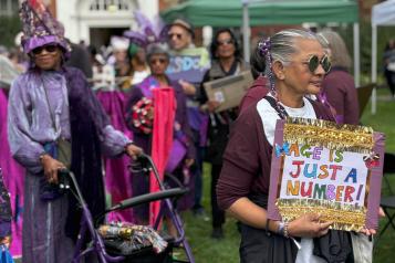 Participants at the Age Well Festival holding a sign that reads, Age Is Just A Number