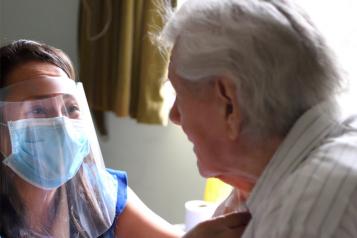 Care home worker in PPE and resident